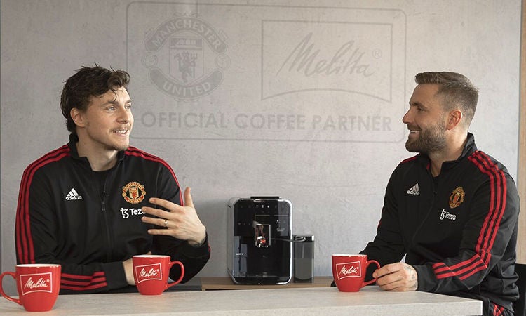 Melitta® ManUnited Shaw Lindelöf Luke Shaw and Victor Lindelöf sitting infront of Melitta FAM with three cups of coffee and chatting